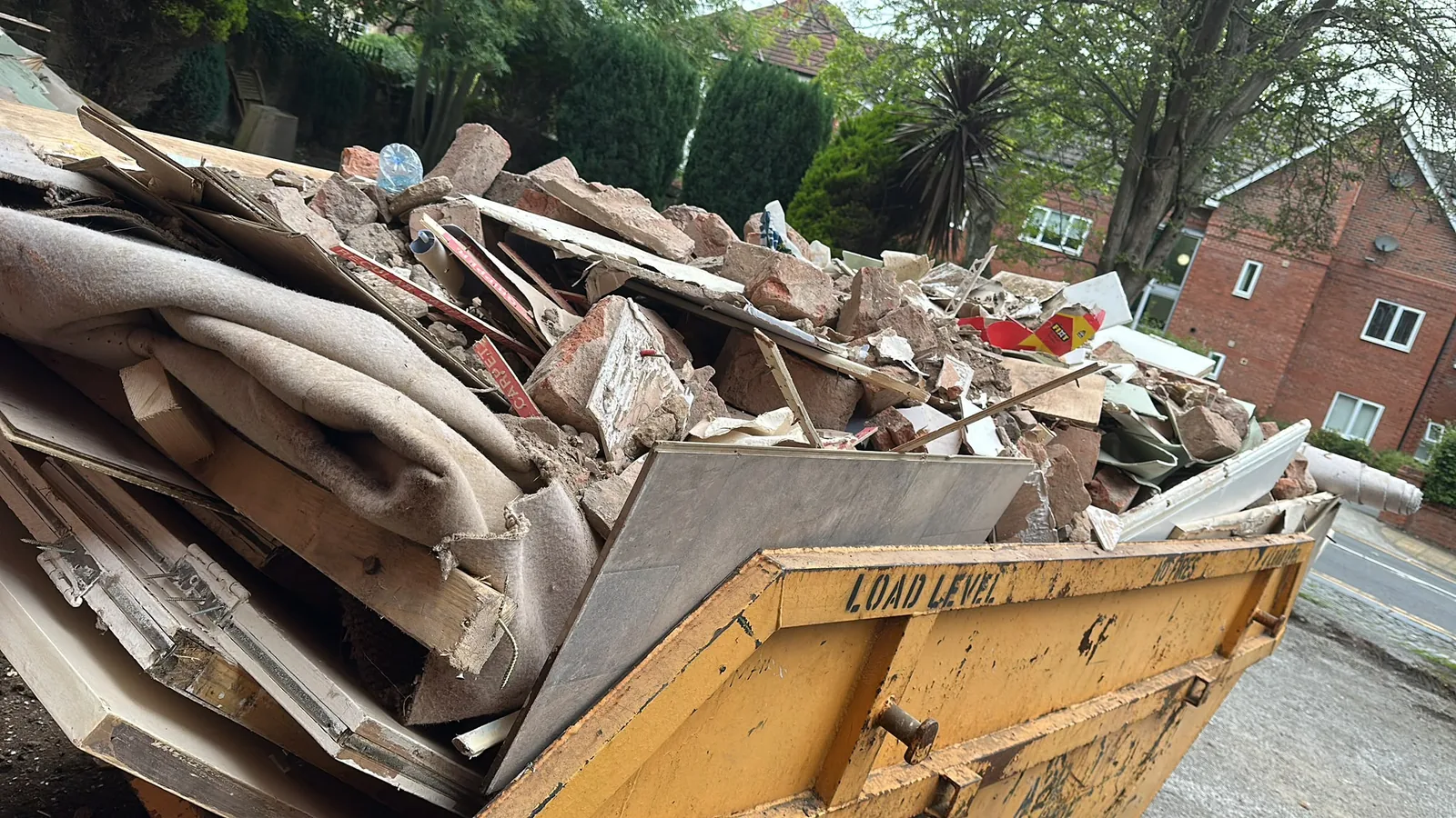 Mixed plasterboard and timber waste loaded into a skip after strip out work