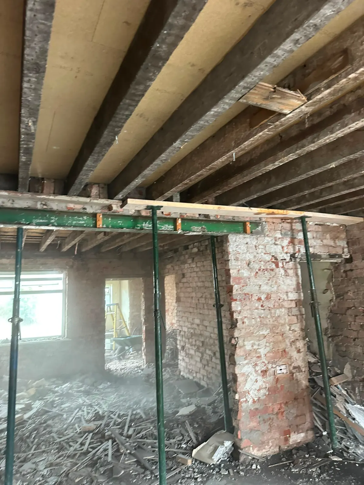 Acrow props and steel beam supporting a structural opening during internal demolition