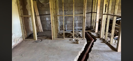 Floor excavation and utility trenching for commercial plumbing systems.